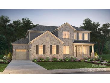 Charming two-story brick home featuring a well-manicured lawn and inviting front porch at 14209 Kershaw Cir # 14, Huntersville, NC 28078