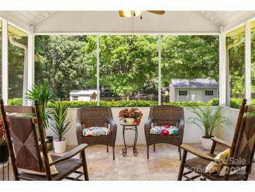 Inviting screened porch with rocking chairs and view of landscaped backyard at 1666 Sam Smith Rd, Fort Mill, SC 29708