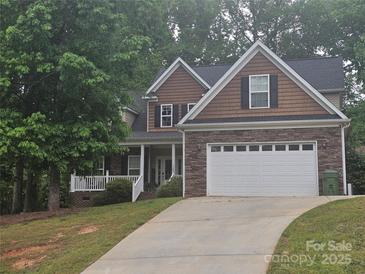 Charming two-story home features a two car garage and a combination of stone, siding, and shake exterior finishes at 4203 Flint Dr, Lancaster, SC 29720