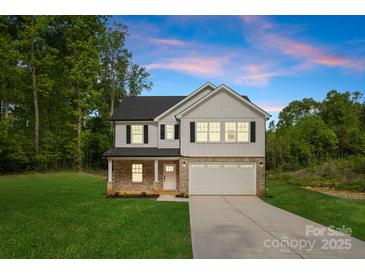Charming two-story home featuring a brick and white exterior, attached garage, and a well-manicured lawn at 5115 Carden Dr, Charlotte, NC 28227