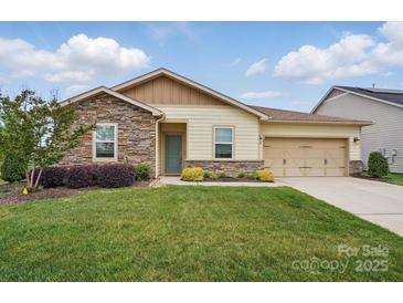 Charming single-story home featuring a well-manicured lawn, stone accents, and an attached two-car garage at 5247 Looking Glass Trl, Denver, NC 28037