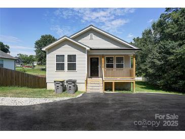 Charming single-story home featuring light beige siding, a cozy front porch, and a newly paved driveway at 809 Fisher St, Kannapolis, NC 28027