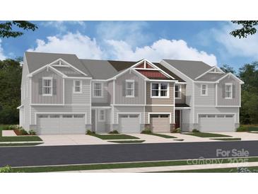 Charming townhome featuring a two-car garage and a beautifully designed facade with gray siding and stone accents at 2017 Vinyasa Ln # Sts-42, Charlotte, NC 28215