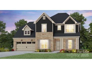 Charming two-story home featuring a stone and dark siding exterior, attached two-car garage, and landscaped front yard at 2214 Riverbend Ave # 22, Monroe, NC 28110