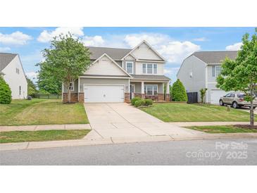 Charming two-story home with manicured lawn, stone accents, and a two-car garage at 306 Fesperman Cir, Troutman, NC 28166