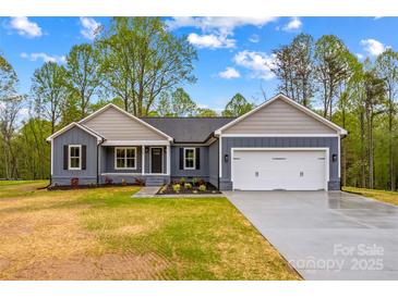Charming single-story home with a two-car garage, landscaped lawn, and inviting front entrance at 750 Whites Farm Rd, Statesville, NC 28625