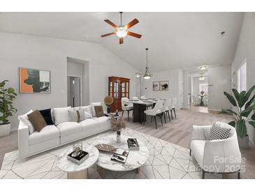 Bright living room boasts modern furniture, decor, and an open floor plan to the dining area, perfect for entertaining at 8313 Carob Tree Ln, Charlotte, NC 28215