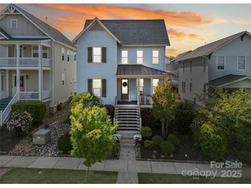 Charming blue two-story home with landscaped front yard and inviting front porch with sunset skies in the background at 962 Herrons Ferry Rd, Rock Hill, SC 29730