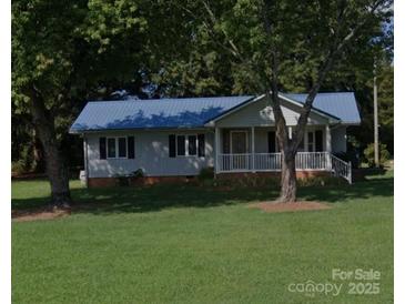 Charming single-story home with a blue metal roof and a well-manicured lawn at , Salisbury, NC 28147