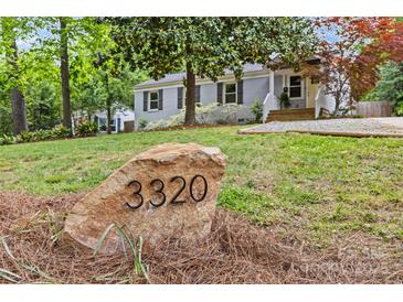 Charming single-story home featuring a stone address marker and a beautifully landscaped front yard at 3320 Eastwood Dr, Charlotte, NC 28205