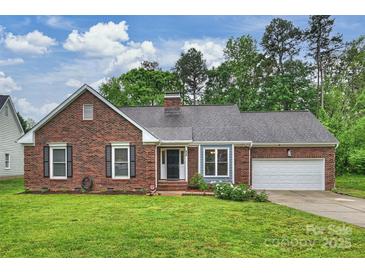 Charming brick home with a manicured lawn, mature trees and an attached two car garage at 616 Trailing Rock Dr, Charlotte, NC 28214