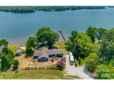 Beautiful waterfront home with a private dock and lush green surroundings on a sunny day at 5200 Masons Ferry Rd, Clover, SC 29710