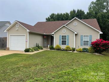 Inviting one-story home featuring a lush front yard with a garage and pleasing exterior siding at 5804 Crosswinds Ct, Indian Trail, NC 28079