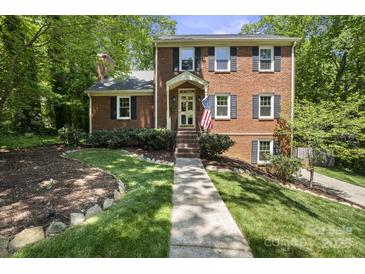 Charming two-story brick home with a well-maintained lawn and landscaped front yard at 9707 Enid Ln, Matthews, NC 28105