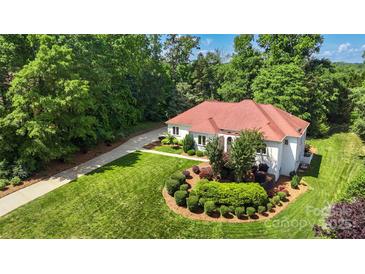 Stunning home with a red roof, lush landscaping, and a circular driveway at 1004 Berwick Ct, Waxhaw, NC 28173