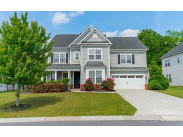 Charming two-story home features a manicured lawn and an attached two-car garage at 2164 Hanging Rock Rd, Fort Mill, SC 29715