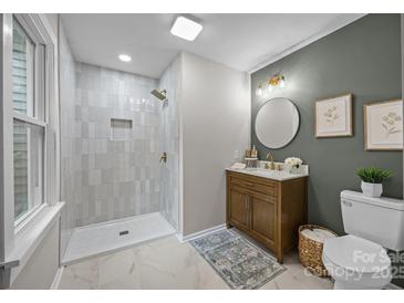Stylish bathroom featuring a walk-in shower, updated vanity, decorative lighting, and neutral paint palette at 322 Corriher Heights Ave, China Grove, NC 28023