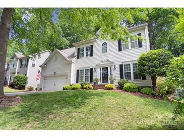Charming two-story white home with black shutters, attached garage and manicured lawn and landscape at 12328 Chickasaw Dr, Huntersville, NC 28078
