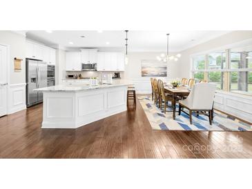 Bright, open kitchen features a large island, stainless steel appliances, and a breakfast nook with natural light at 15702 Guthrie Dr, Huntersville, NC 28078