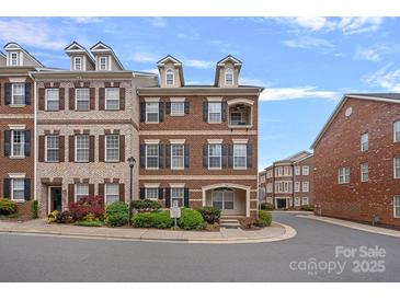 Charming brick townhome with dormer windows and manicured landscaping on a tree-lined street at 1948 Winpole Ln, Charlotte, NC 28273