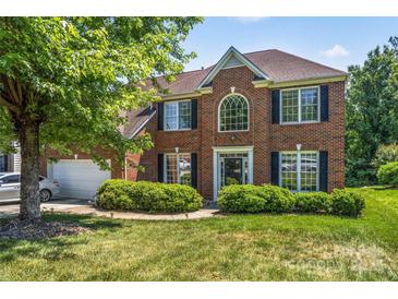 Lovely brick home featuring lush green landscaping, manicured lawn and a two-car garage at 3124 Arklow Rd, Charlotte, NC 28269