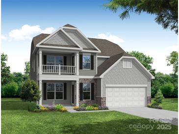 Charming two-story home featuring a covered front porch, second story balcony, and a two-car garage at 3242 Bozeman Ct # 8, Stanley, NC 28164