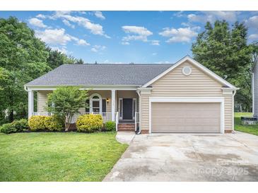Charming single-Gathering home with a well-manicured lawn, covered porch, and attached garage, perfect for comfortable suburban living at 7106 Kinsmore Ln, Charlotte, NC 28269
