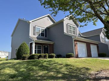 Inviting two-story home with manicured lawn and a two-car garage, perfect for suburban living at 12120 Stratfield Place Cir, Pineville, NC 28134