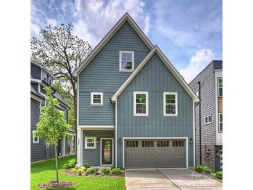 Charming two-story home featuring a gray exterior, a well-manicured lawn, and an attached garage, blending comfort with curb appeal at 205 Coxe Ave, Charlotte, NC 28208