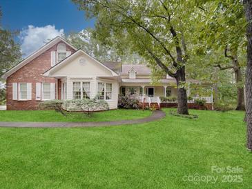 Charming home with manicured lawn, front porch, and a blend of brick and siding at 2721 Tara Dr, Monroe, NC 28112