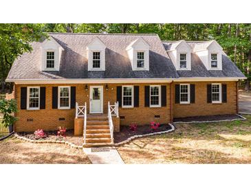 Charming brick home featuring a classic design with black shutters and a well-manicured front yard at 328 Earl Griffin Rd, Monroe, NC 28112