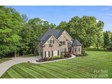 Elegant brick home with a manicured lawn and lush landscaping provides charming curb appeal at 3398 Millstone Creek Rd, Lancaster, SC 29720