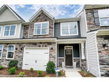Beautiful townhome exterior features stone accents, a front-entry garage, and a welcoming front porch at 4248 Black Ct # 232, Harrisburg, NC 28075
