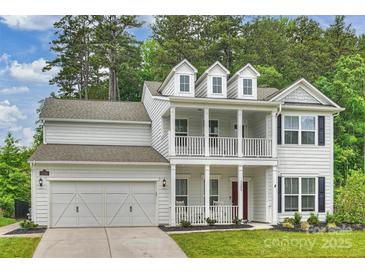 Charming two-story home with inviting double porch, manicured lawn, and attached two-car garage at 7209 Brookline Pl, Huntersville, NC 28078