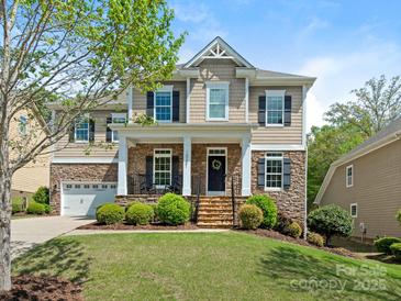 Charming two-story home with manicured lawn, stone accents, and a welcoming front porch at 10201 Daufuskie Dr, Charlotte, NC 28278