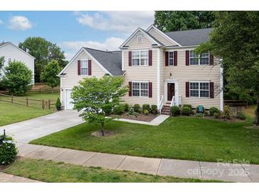 Charming two-story home with tan siding, maroon shutters, well-manicured lawn, and lush landscaping at 10508 Madison Park Dr, Charlotte, NC 28269
