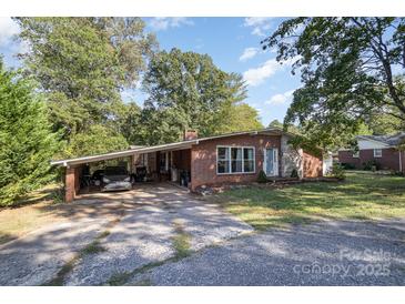Cozy brick home with mature trees, covered carport, and a well-maintained front yard at 1239 Christopher Cir, Rock Hill, SC 29730