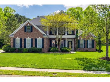 Traditional two-story brick home with manicured lawn and black shutters at 2235 Legacy Oak Dr, Waxhaw, NC 28173