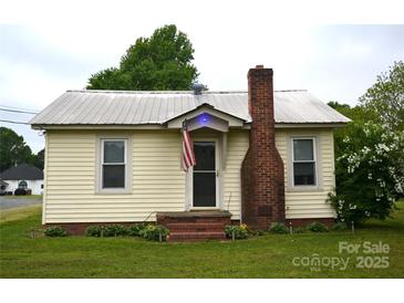 Charming one-story home with a brick chimney, a brick staircase, and a tidy front yard at 303 Nc Hwy 200 N Hwy, Stanfield, NC 28163