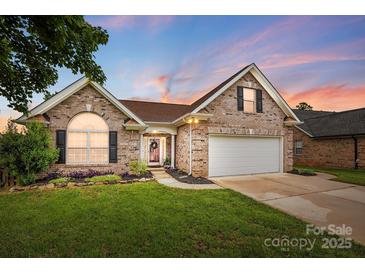 Charming brick home with manicured lawn, attached two-car garage, and welcoming front porch at 3327 Flagler Cir, Midland, NC 28107