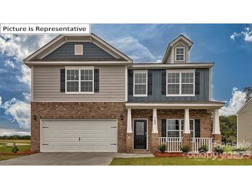 Charming two-story home featuring a brick and siding facade, a two-car garage, and a welcoming front porch at 3414 Lacebark Ln, Gastonia, NC 28056
