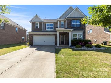 Charming two-story home featuring a well-maintained lawn, brick accents, and a two-car garage, offering curb appeal at 3424 Windstone Ln, Gastonia, NC 28056