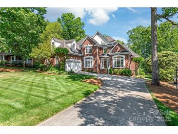 Elegant brick home boasts a manicured lawn, mature trees, and a spacious driveway at 4232 Shannamara Dr # 85, Matthews, NC 28104