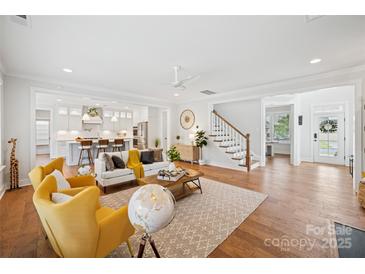 Open-concept living room flows to kitchen, showcasing hardwood floors and a cozy, inviting atmosphere at 528 Rock Skip Way, Fort Mill, SC 29708