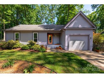 Charming one-story home with a well-manicured lawn, mature trees, and inviting front entrance at 901 Southland Rd, Huntersville, NC 28078