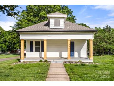 Charming bungalow featuring a covered front porch with wood columns, fresh white paint, and manicured lawn at 906 Church St, Kings Mountain, NC 28086