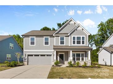 Charming two-story home with a gray exterior, covered porch, and well-maintained landscaping at 1308 Stone Marker Dr, Monroe, NC 28112