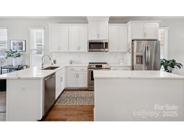 Bright kitchen features white cabinets, stainless appliances, and a spacious quartz countertop island at 2111 Isom St, Charlotte, NC 28208