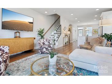 Bright living room features a decorative rug, hardwood floors, and comfortable seating at 2111 Isom St, Charlotte, NC 28208