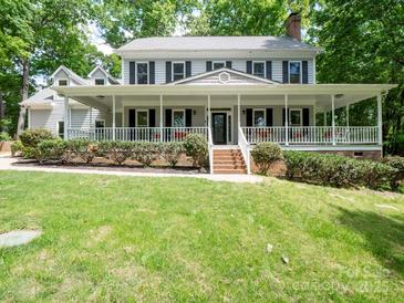 Charming home featuring a full front porch, black shutters, brick steps, and a lush green lawn at 2329 Wedgewood Dr, Matthews, NC 28104